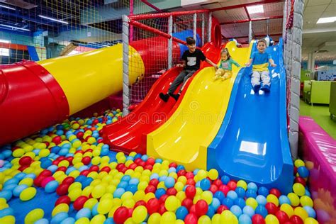 kinderen spelen in een kleurrijke indoorspeelplaats met glijbaan