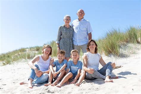 Gezinsfoto op het strand van Zeeland met spelende kinderen en honden