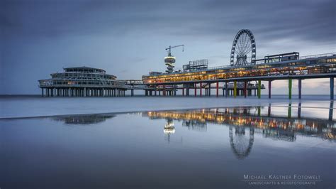 Foto van De Pier in Scheveningen 's avonds, met verlichting en mensen die genieten van een feest.