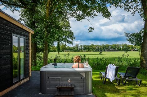 Luxe boshuisje met een privé hottub op het terras, omgeven door bomen