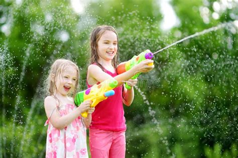 Kinderen spelen in een Water Playhouse met waterkanonnen en een grote wateremmer