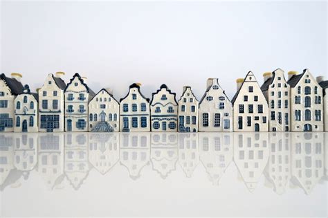 Illustratie van verschillende KLM Delfts Blauwe huisjes met een korte uitleg over hun oorsprong.