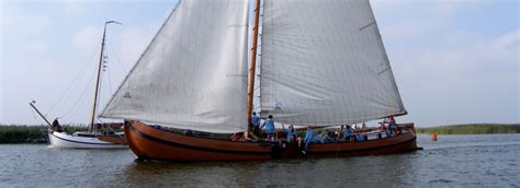 Zeilboten op een Fries meer met op de achtergrond groene weiden