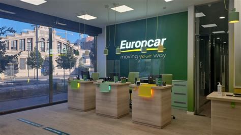 Overzicht van de Europcar balie op Tirana Airport, met diverse huurauto's op de achtergrond.