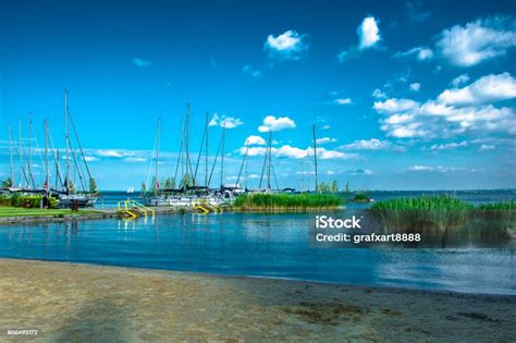 Zicht op het Balatonmeer met strand en boten.