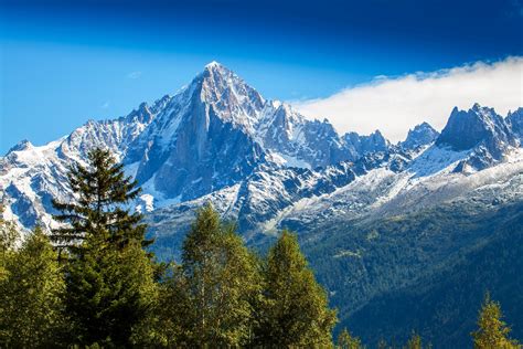 Panorama van de Franse Alpen met wandelpaden en besneeuwde bergtoppen.