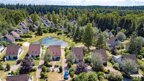Uitzicht op de Pyreneeën vanaf een vakantiepark met een recreatiemeer op de voorgrond.