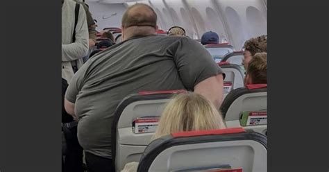 Een passagier die ontspannen leest in een comfortabele stoel in de luchthaventerminal tijdens een lange overstap.