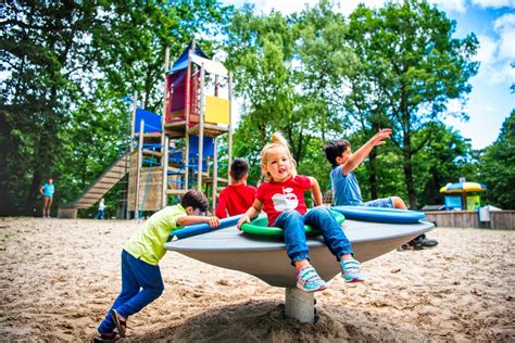 Kinderen spelen op een speeltuin op de camping