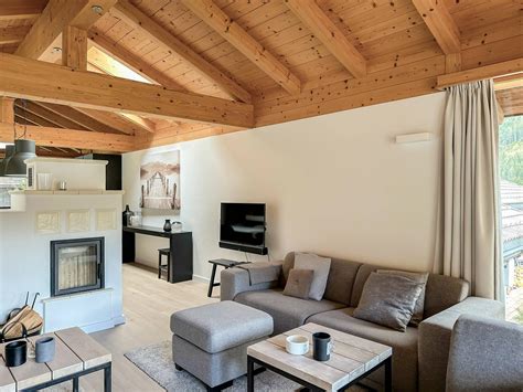 Interieur van een sfeervol Oostenrijks chalet met houten balken, open haard en comfortabele zitmeubelen