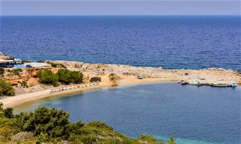 Luchtfoto van een breed zandstrand op Kos met ligbedden en parasols
