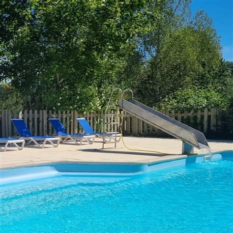 Buitenzwembad van Camping La Bonne Vie, omringd door groen en ligbedden.