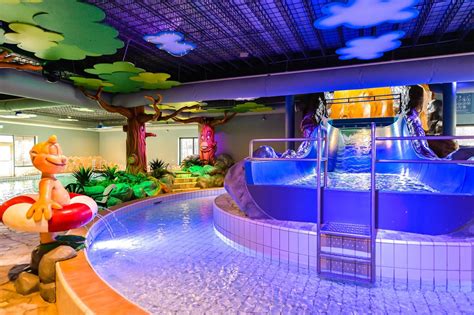 Een gezin geniet van het binnenzwembad op een vakantiepark in Utrecht.