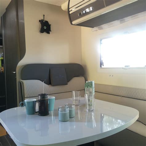 Interieur van een moderne camper, met keukenblok, zitgedeelte en slaapplaatsen.