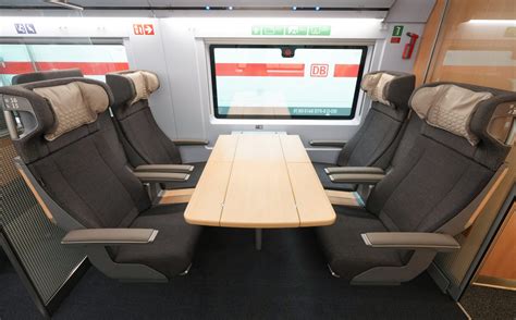 Interieur van een ICE-trein van Deutsche Bahn met ruime zitplaatsen en tafels.