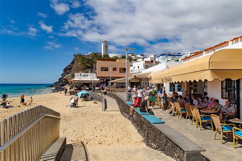 De haven van Morro Jable met diverse boten aangemeerd en op de achtergrond de stad en bergen.
