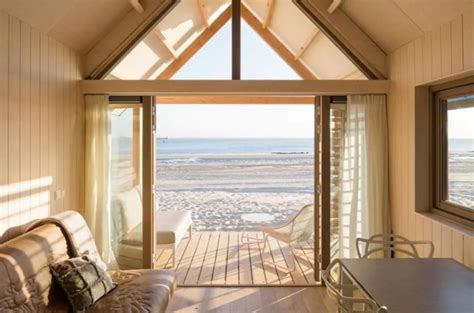 Een sfeervolle veranda van een strandhuisje met uitzicht op zee en duinen.