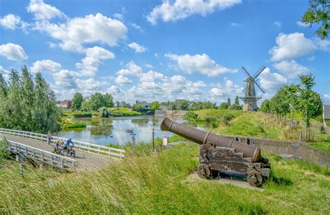 Een glooiend Achterhoeks landschap met kronkelende fietspaden en karakteristieke boerderijen.