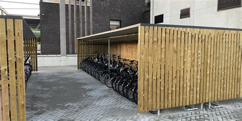 Een fietsenstalling met oplaadpunten voor elektrische fietsen bij een hotel.