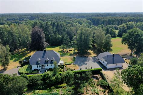 Illustratie van een ruime groepsaccommodatie in een bosrijke omgeving met gezellige buitenruimte