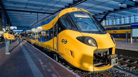 Foto van een trein die door een bergachtig landschap rijdt in Nieuw-Zeeland.