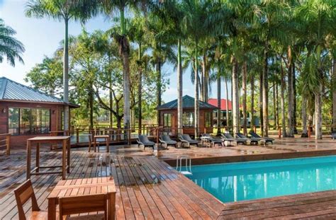 Luchtfoto van Plantage Resort Frederiksdorp met de Commewijne Rivier op de voorgrond en de historische gebouwen omgeven door groen.
