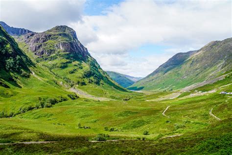 Een panoramisch uitzicht over de Schotse Hooglanden met mistige bergen en groene valleien.