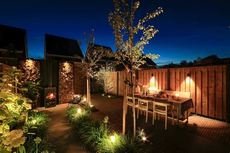 Foto van de buitenjacuzzi en tropische tuin bij Osiam, met sfeervolle verlichting.