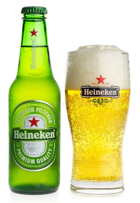 Fles alcoholvrij bier van Heineken naast een glas op een vliegtuigtafel