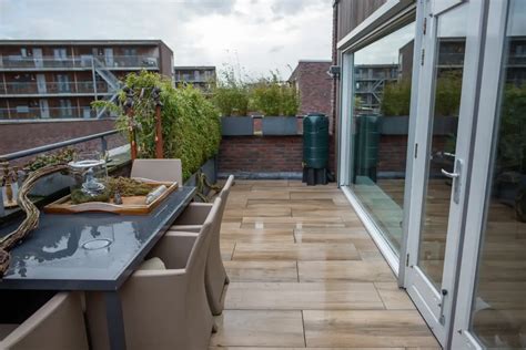 Een weelderig aangelegd dakterras met tropische planten en een overkapping