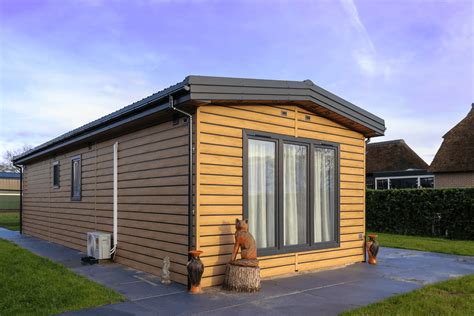Illustratie van een stacaravan met permanente aansluitingen en bijgebouw
