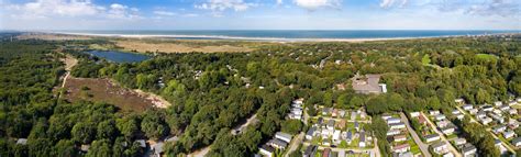 Luchtfoto van Roompot Vakantiepark Kijkduin met de duinen en de Noordzeekust op de achtergrond