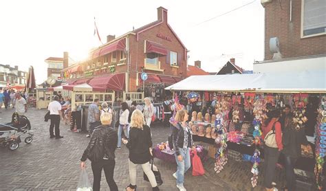 Levendige zomerse braderie in het centrum van Egmond aan Zee met diverse kraampjes.