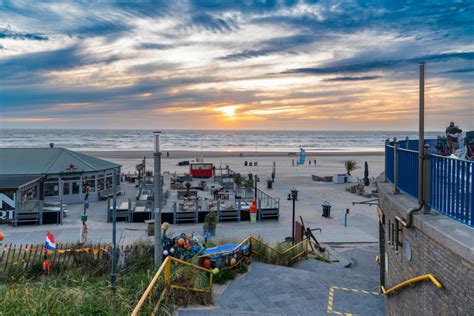 Gezinsvriendelijk strand van Egmond aan Zee met strandpaviljoens en speelende kinderen.