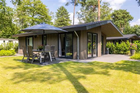 Een sfeervolle bungalow op een groen vakantiepark, omringd door natuur.