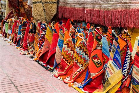 Foto van de levendige souks van Oujda met kleurrijke tapijten en ambachtelijke producten.