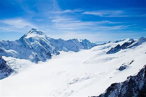 panoramisch uitzicht op de Zwitserse Alpen met besneeuwde toppen en groene valleien