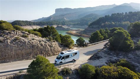 Een camper die geparkeerd staat met een prachtig landschap op de achtergrond.