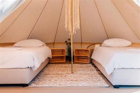 Interieur van een luxe ingerichte tipi met comfortabele bedden en sfeerverlichting