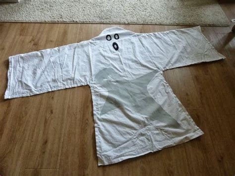 Eenvoudig spookkostuum maken van een oud laken met uitgesneden gezicht.