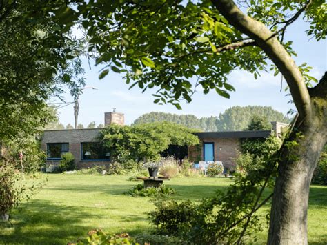Een foto van een sfeervolle bungalow, omringd door groen.