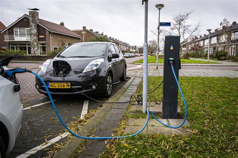 Een elektrische auto wordt opgeladen bij een laadpaal in de stad