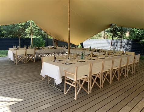 Een sfeervolle foto van het strandpaviljoen met tafels en stoelen, klaar voor gasten.