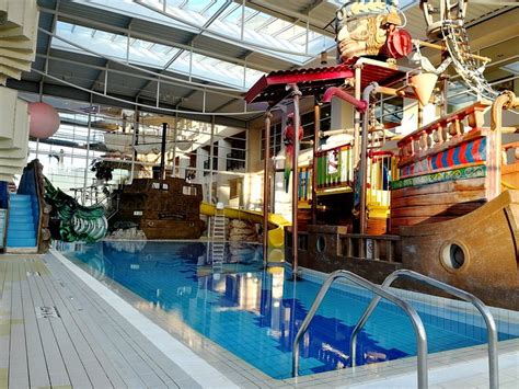 Foto van het Explorers Hotel met een piratenschip en glijbanen, en een foto van het Grand Magic Hotel