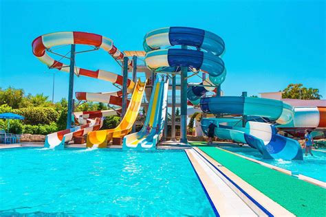 Een gezin geniet van het zwembad met glijbanen in een kindvriendelijk hotel op Zakynthos