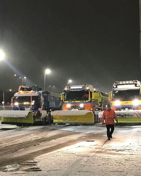 foto van de besneeuwde platforms van Schiphol met sneeuwschuivers en de-icing voertuigen