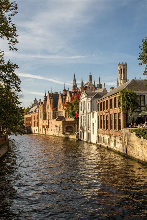 Een rondvaartboot vaart door een kanaal in Brugge onder een oude stenen brug