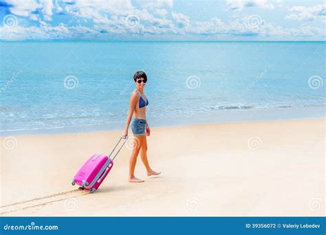 Vrouw met koffer op een zonnig strand