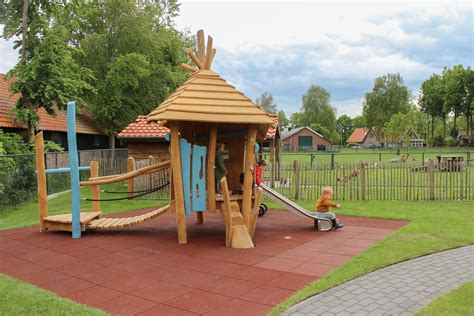 Kleuterhof met kleurrijke speeltoestellen en zachte ondergrond