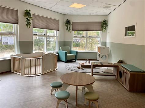 Een babyruimte met verschoontafel en comfortabele stoelen